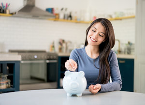 woman adding money to piggy bank